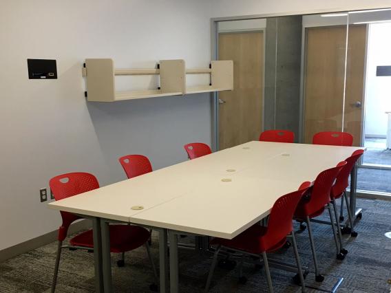 Photo of room N572 in ENR2 with one table and 8 chairs surrounding it.