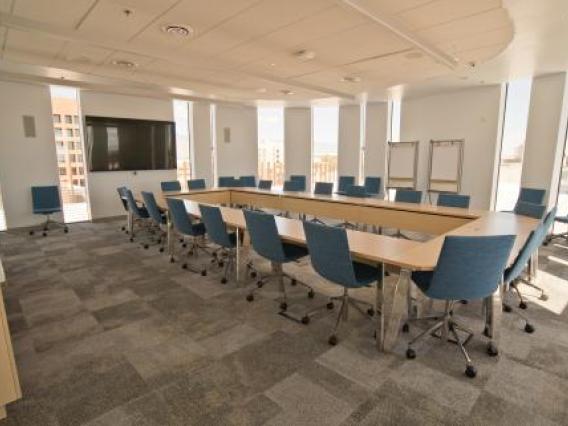 Photo of room N604 in ENR2 with multiple tables and chairs as well as a monitor mounted to the wall..
