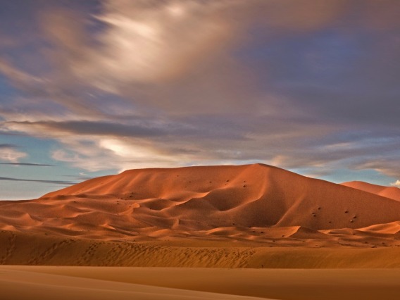 Sand dunes under a cloudy sky.