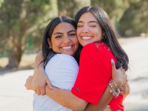 Two women smiling and hugging each other