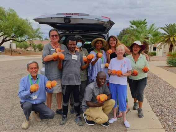 Ishkashitaa members holding produce outside of a grey SUV