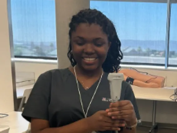 Jada Jenkins: Woman with dark curly hair wearing black scrubs