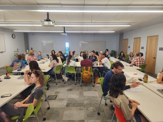 Group of students and mentors sitting in semi-circle tables