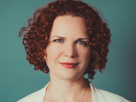 Headshot of Elena Chernova-Davis with blue background. 