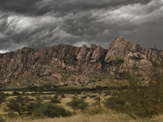 Desert mountains under grey clouds.