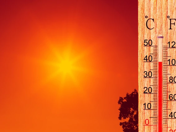 A hot sun in the background with a thermometer in the foreground.