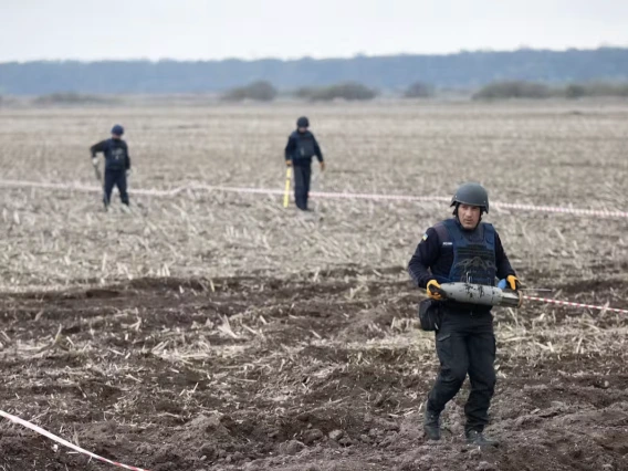 Militants walk across a bare field.