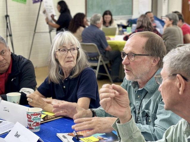 Picture of people around a table talking
