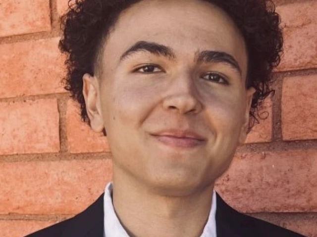 Headshot of Ryan Green in front of a red brick wall