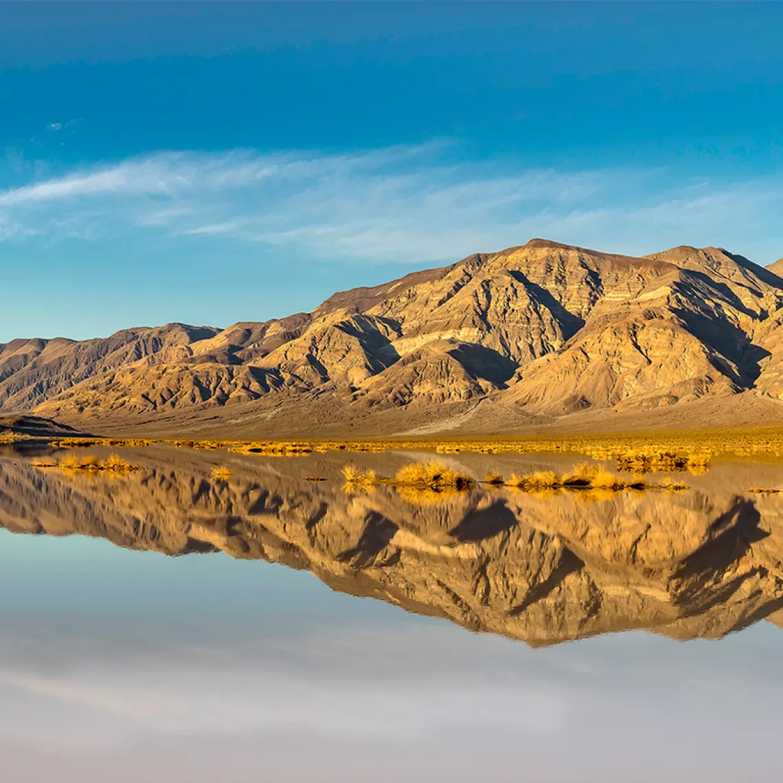 Mountains in death valley being reflected in the water.