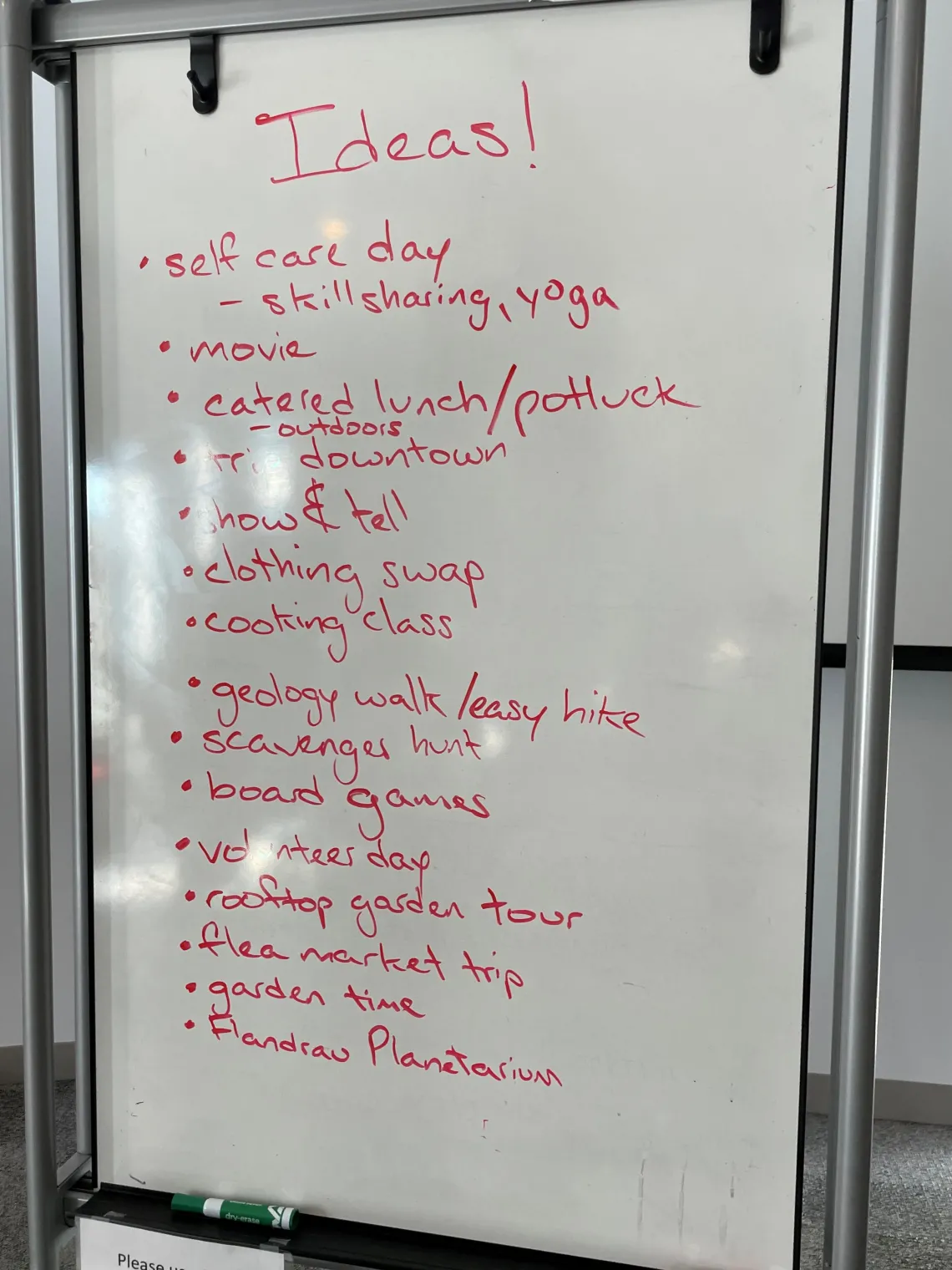 A white board with ideas written on it including topics like "Self care day", "catered lunch", and more.