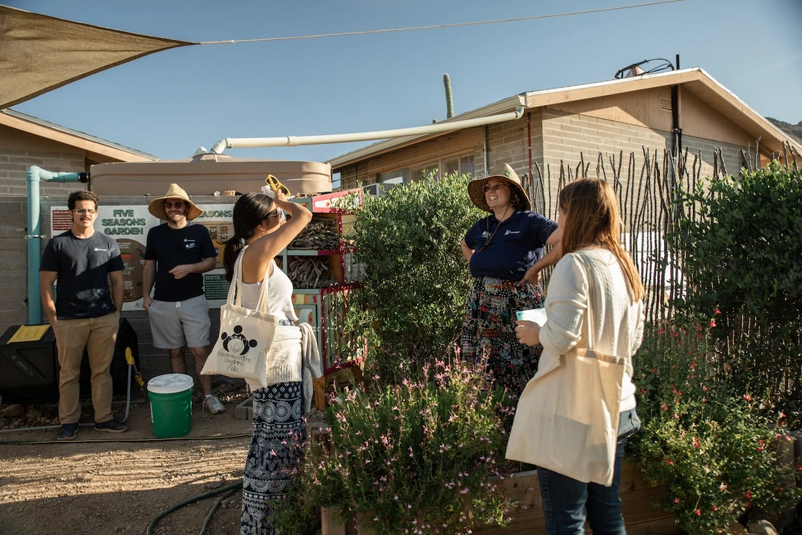 People stand outdoors at a community garden.