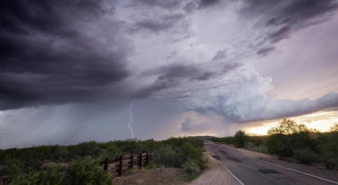 A monsoon storm over a lonely road in the desert.