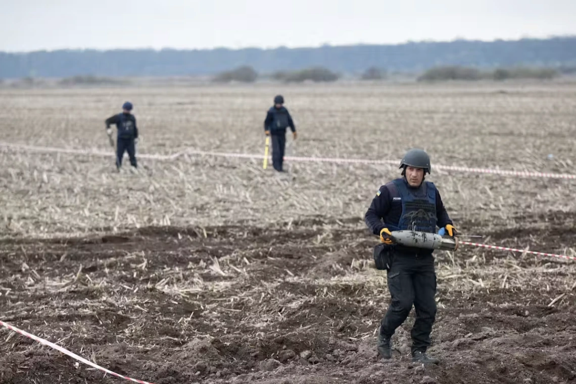 Militants walk across a bare field.