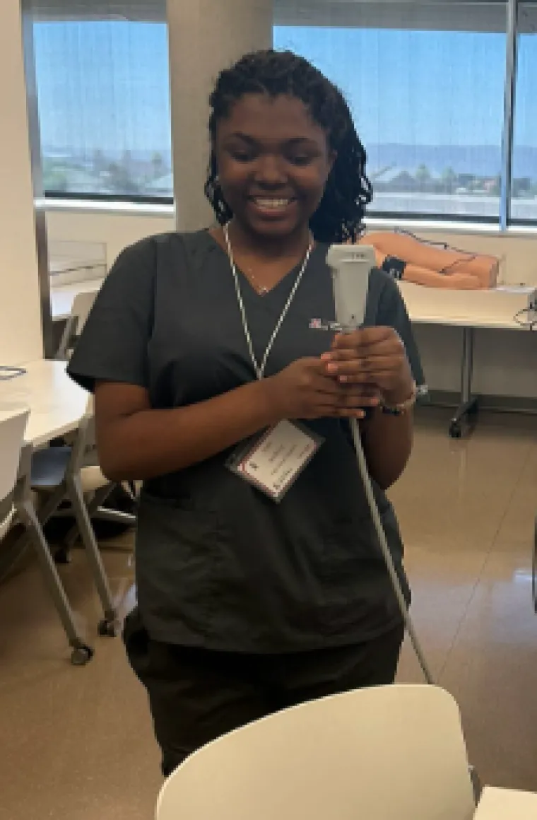 Jada Jenkins: Woman with dark curly hair wearing black scrubs