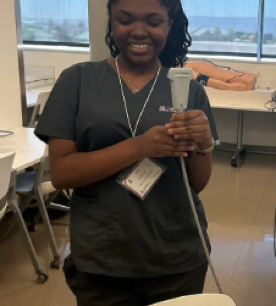 Jada Jenkins: Woman with dark curly hair wearing black scrubs