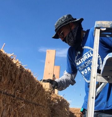 Earth Grant student Daniel Vega building with straw bales.