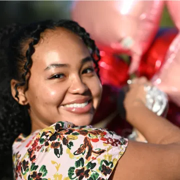 A woman is smiling in a flower shirt