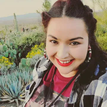 Smiling student with red lipstick and desert scape