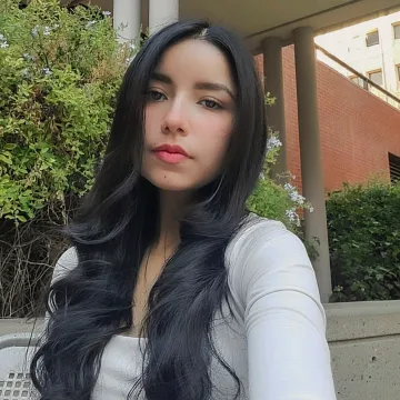 Student with dark hair in front of plant