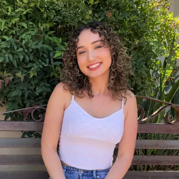 Smiling student with curly hair wearing a white shirt