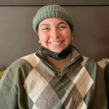 Smiling student wearing a green hat