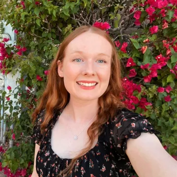 Student in front of pink flowers