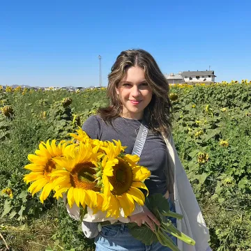 Smiling student holding sunflowers 