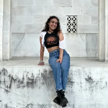 Student sitting on white stone