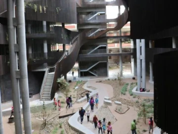 An image of the interior of the ENR2 courtyard, with ivies, balconies, and a spiral staircase.