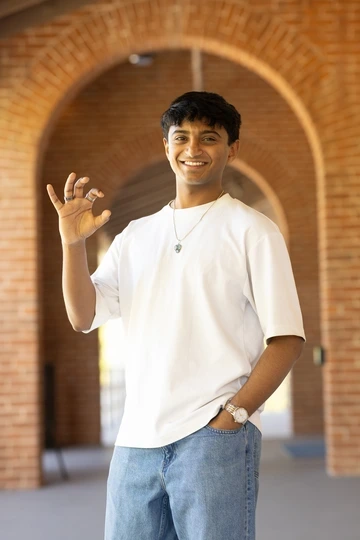 Ojas Sanghi poses on the U of A campus making the "wildcat" hand symbol.