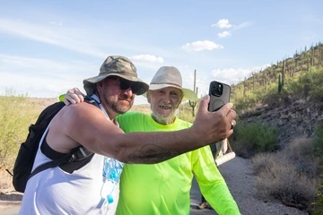 A younger man takes a selfie with Taylor.