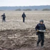 Militants walk across a bare field.